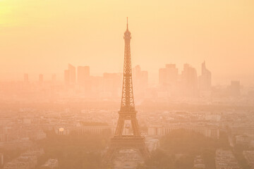 Aerial view of Paris with Eiffel tower and major business district of La Defence in background at sunset.
