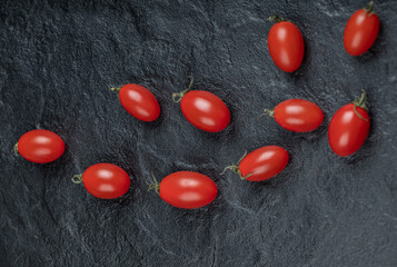 Small cherry tomatoes on black background