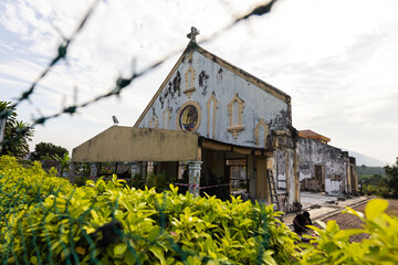 Kuala Lumpur, Malaysia - December 24, 2020: the ruin of a church behind barbed wire. The dilapidated building is about to collapse. The christian community in malaysia is in the minority