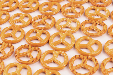 White background filled with neatly laid out salty crackers close-up