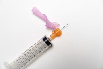 Empty 10mL syringe with an orange 25G hypodermic needle attached
