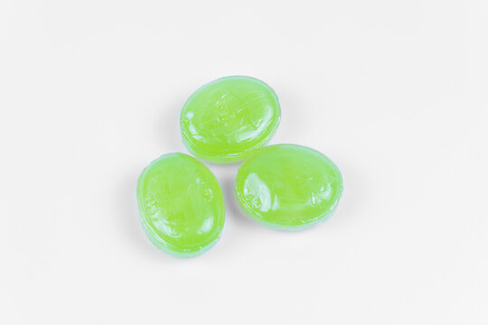 Three green caramels centered on a pure white background