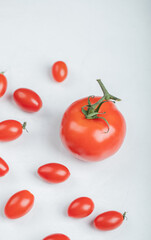 Cherry tomatoes around of normal tomato