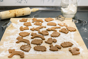 Cookies cut from gingerbread dough. Rolling pin and cookie cutters. Christmas gingerbread in the shape of animals.