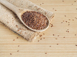 Flax seed on wooden ladle on wooden background. raw food for health concept.