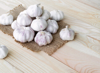 Garlic on hemp sack with wooden background. herb raw food for health concept.