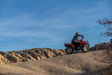 Obraz premium Tourists on safari in Cappadocia with ATV vehicles with views of beautiful fairy chimneys and vineyards