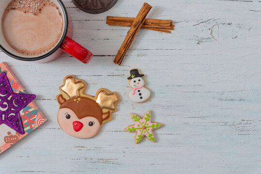 Christmas cookies on vintage wood table, cinnamon and hot chocolate.