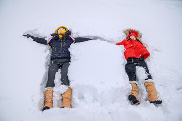 Mom and daughter play in the snow happily.