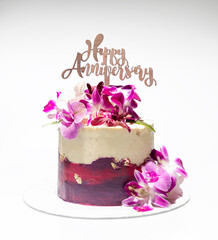 Yellow, red and purple coloured ribbon cake with purple and white fresh orchids