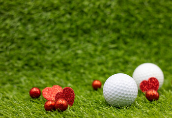 Naklejka premium Golf ball for Valentine's Day with red heart are on green grass with love
