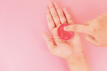 woman using petroleum jelly onto skin at home close up.