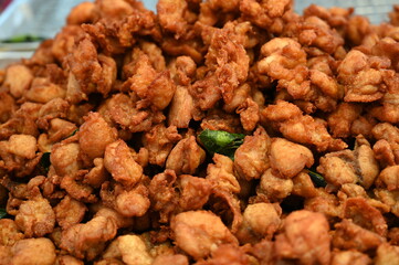 Close-up of crispy chicken made from small pieces of chicken marinated with spices and sauces. Mixed with fried batter with kaffir lime leaves in hot oil, available in store with steamed sticky rice. 