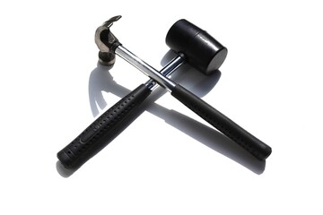 Black rubber hammer and iron hammer cross intersect isolated on white background closeup.