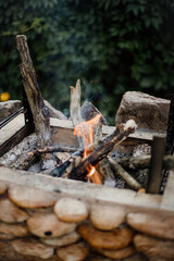 Bonfire lighted from wood in the grill at their summer cottage. Bright flame from the fire.