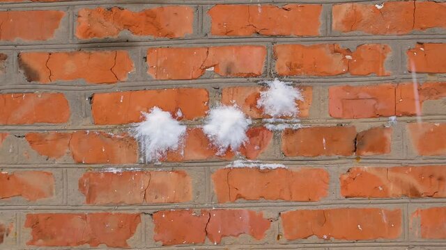 Throwing snowballs at a red brick wall. Play snowballs in winter. School break. Winter season. Hit the target with snow. Merry Christmas. Christmas mood. Childrens games. New Year.