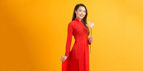 Vietnamese girl holding a lotus flower, The Ao dai ( long-dress Vietnamese) is traditional costume...