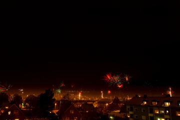 Obraz premium Fireworks on a dark sky over city skyline