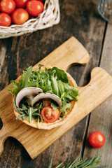 Hot appetizer with mushrooms, chicken and herbs. Tartlet made of yeast-free dough close-up.