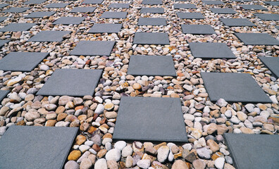 square pavers with small stones around the pavers