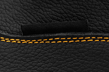 Yellow stitches on the leather of boots. Macro photo.