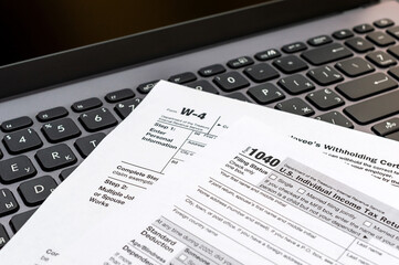 Obraz premium Tax forms on laptop keyboard.