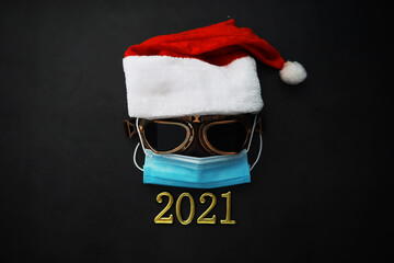 Santa Claus hat, glasses and nose with face mask on red background. Christmas or New Year celebration concept.