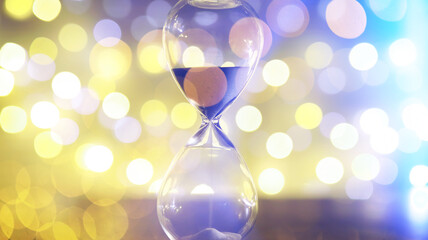 Hourglass and Christmas background. Christmas, new year, copy space, bokeh.