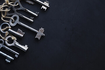 Set of vintage keys for a lock. Retro keys on a dark stone background. The concept of choosing the...