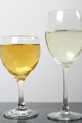 Two wine glasses with cider, light yellow is normal cider, dark yellow is reduced cider, one-third remains after boiling.