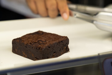 Pieces of fresh brownie on white dish.