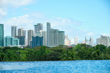 Fototapeta na wymiar View of the city of Manila from the pool of the luxury five-star Discovery Primea hotel. Sunny weather. Skyscrapers on the background.