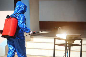 Health workers in sterile clothing are spraying chemicals to prevent the COVID-19 virus
