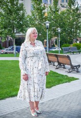  Beautiful woman on a walk in the city. Spring - summer time. A nice middle aged plus size woman at the street. Citizen lifestyle