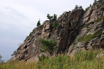 Rocky ledges of the mountain Babyrgan against the blue sky in Altai in Russia.