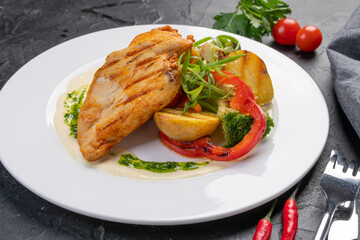 Grilled turkey fillet with vegetables on a white plate for the restaurant menu. The view from the top.