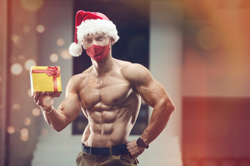Fitness man in Santa Claus hat costume in gym
