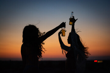 Women in bikinis partying and dancing at summer beach party
