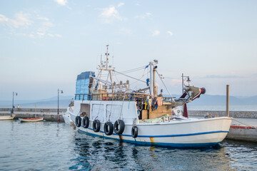 Fototapeta premium Evia island, Greece - June 28. 2020: Anchored fishing boat, moored to the waterfront 