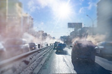 pollution from the exhaust of cars in the city in the winter. Smoke from cars on a cold winter day