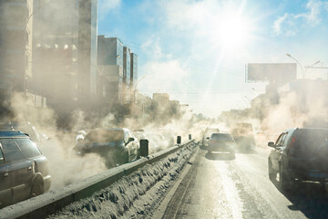 pollution from the exhaust of cars in the city in the winter. Smoke from cars on a cold winter day