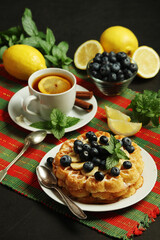 Belgian waffles with blueberry and a cup of tea with lemon