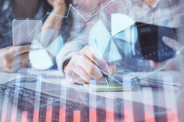 Double exposure of man and woman working together and financial graph hologram. Business concept. Computer background.