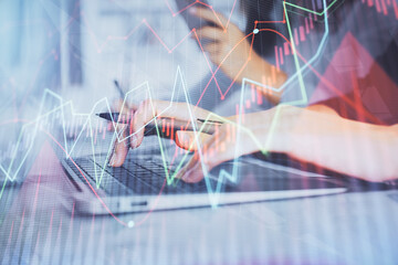 Multi exposure of woman hands typing on computer and financial graph hologram drawing. Stock market analysis concept.