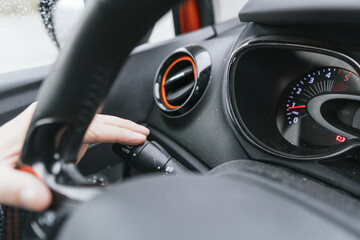 man's hand in the car putting the turn signal. driving concept