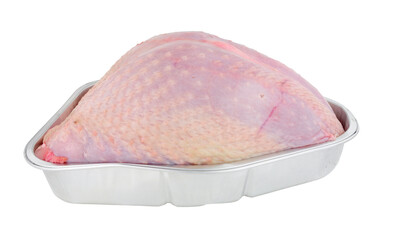 Whole raw turkey crown meat in a foil roasting tray isolated on a white background