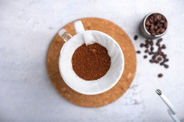 Drip brewing, filtered coffee or pour-over is a way of making coffee. Barista preparing drip on iced on coffee ground coffee beans contained in a filter paper. Top view.
