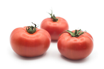 Closeup of organic flat tomatoes on white background