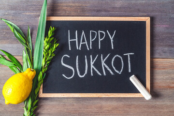 inscription "Happy Sukkot", Lulav and Etrog on chalkboard.