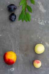 Fruits with leaves top view on the gray old fabric background. Flat lay.